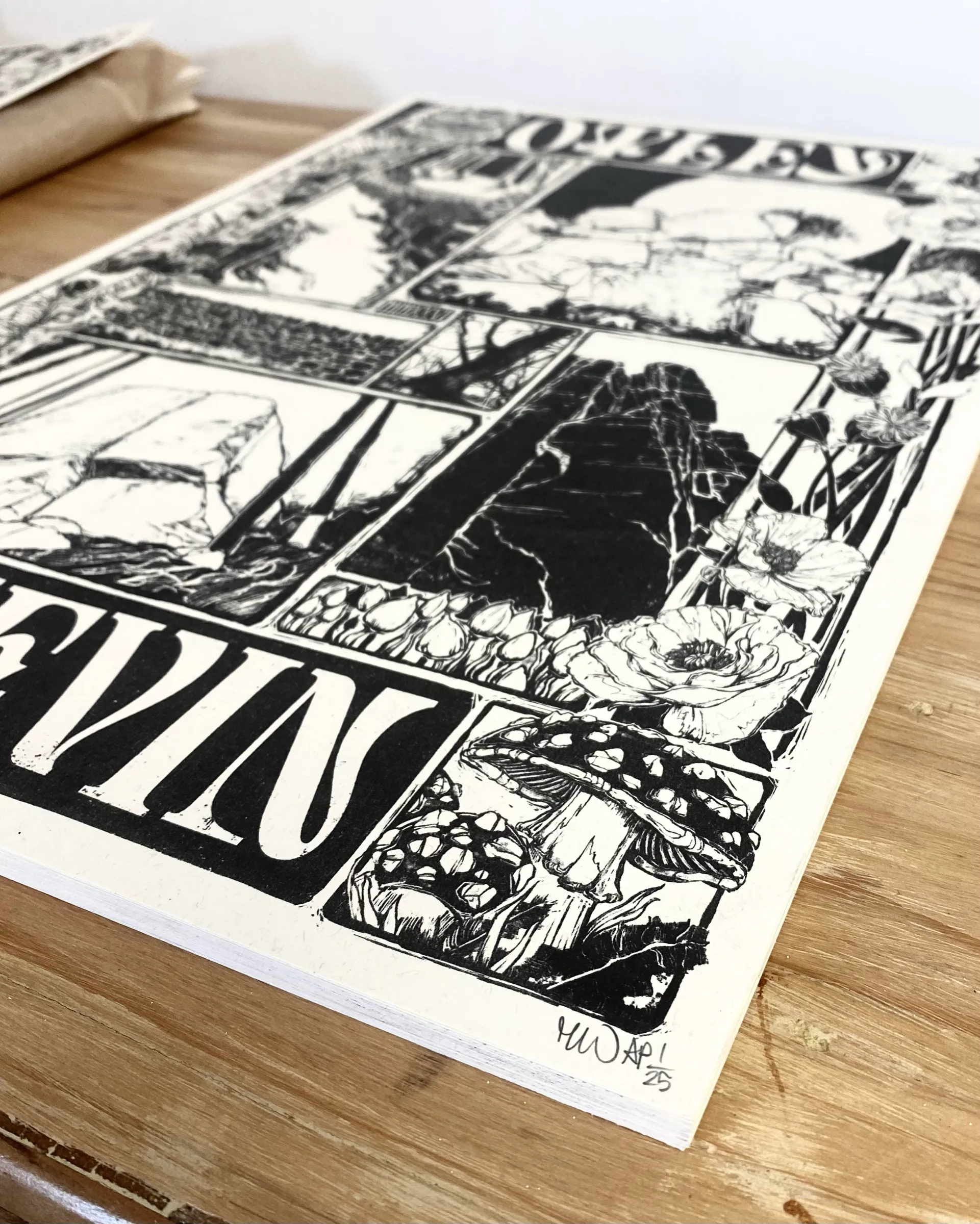 The print at an angle on a wooden table, signed in pencil.