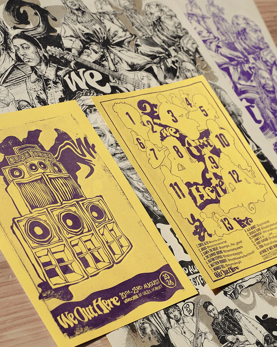 Yellow festival flyers with a drawn sound system, fanned over black and white prints.