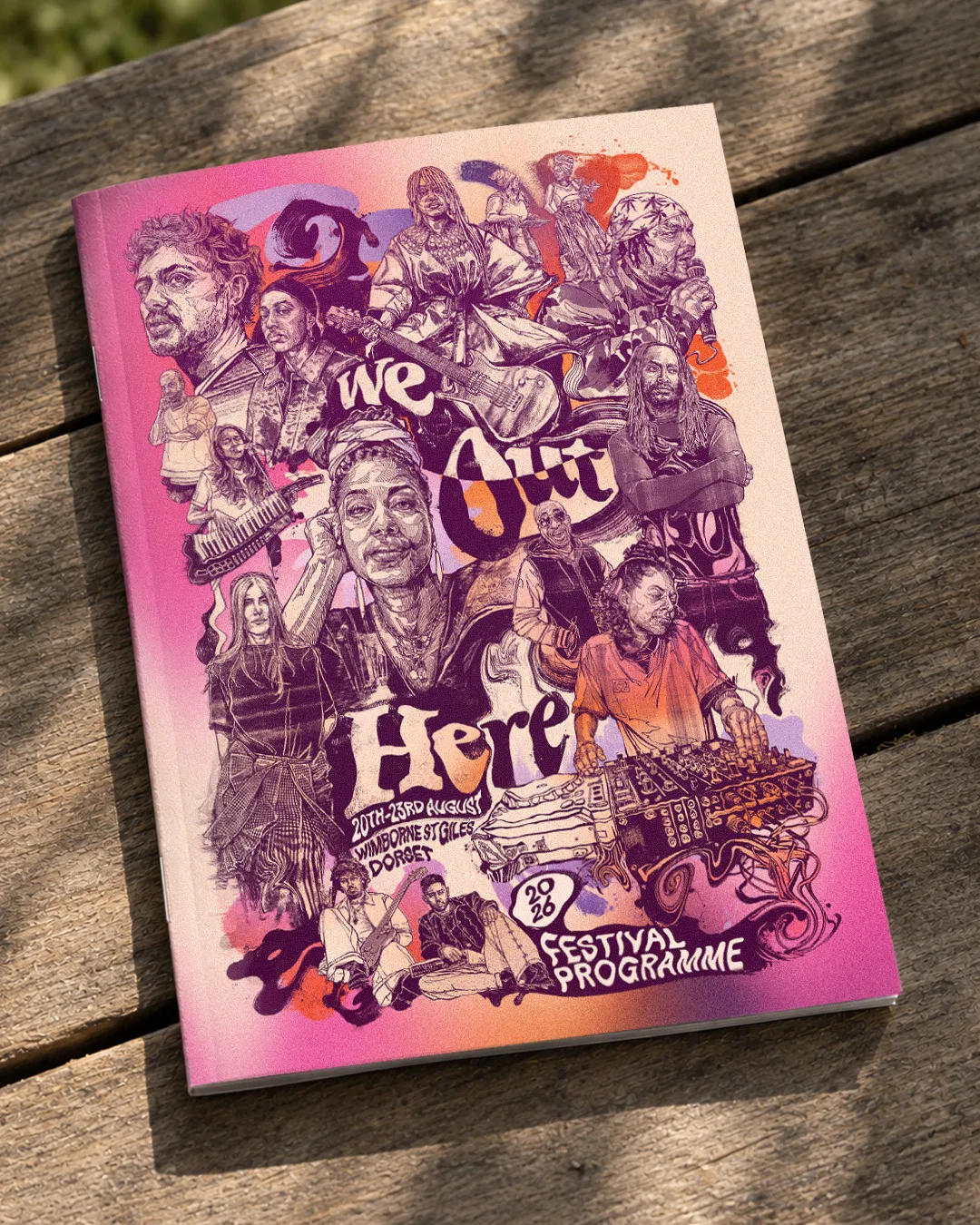 The 2026 festival programme, its pink cover printed with the poster artwork, lying on a sunlit wooden table.